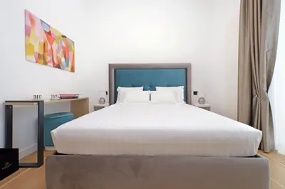 a bedroom with a large white bed and a desk at Domus Aurea Luxury Suites in Rome