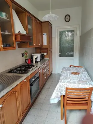 a kitchen with wooden cabinets and a table with a microwave at Iannilli Casa Vacanze in Rome