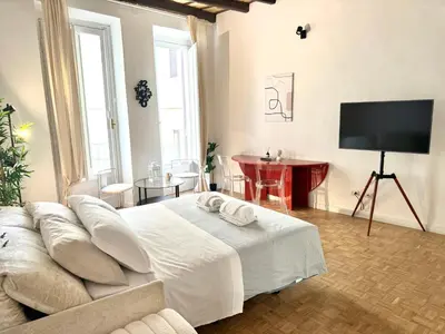 a bedroom with a white bed and a table at Luxury Apartment Historic Center in Rome