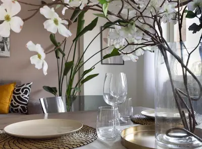 a table with glasses and a vase with white flowers at Balduina Retreat Terrace in Rome