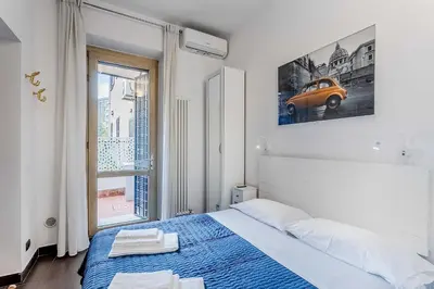 a bedroom with a bed with a blue blanket and a car on the wall at Vatican Bridge Home in Rome