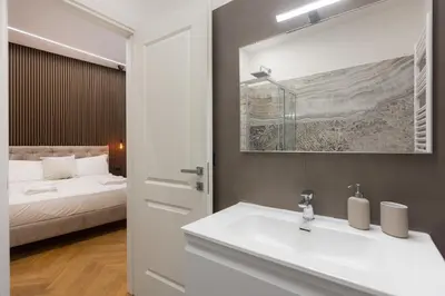a white bathroom with a sink and a bed at Luxury Suite Coronari in Rome