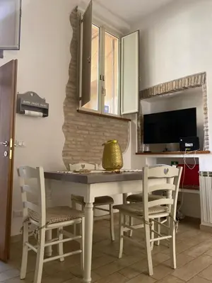 a kitchen with a table and chairs and a television at B&B trastevere il vicolo in Rome
