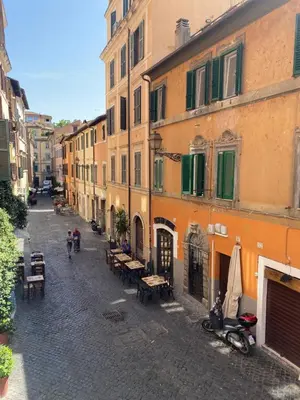 an alley with tables and benches in a city at B&B trastevere il vicolo in Rome