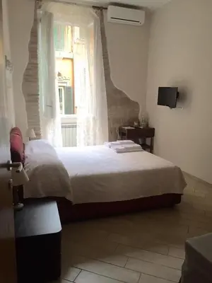 a bedroom with a large bed and a window at B&B trastevere il vicolo in Rome
