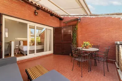 a patio with a table and chairs and a bedroom at Rasella 21 - FromHometoRome in Rome