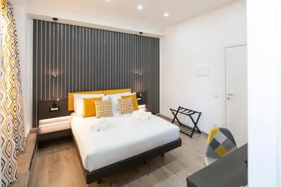 a bedroom with a large white bed with orange pillows at Trastevere New Luxury Rooms in Rome