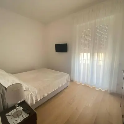 a white bedroom with a bed and a window at Appartamento Villa Ada in Rome