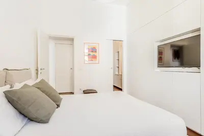 a white bedroom with a white bed and a tv at Casa Jordan 47 in Rome
