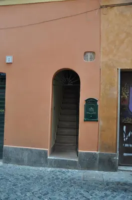 an orange building with stairs leading into a doorway at Casa del Giglio in Rome