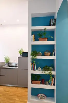 a white book shelf with potted plants in a kitchen at At Home Montebello in Rome