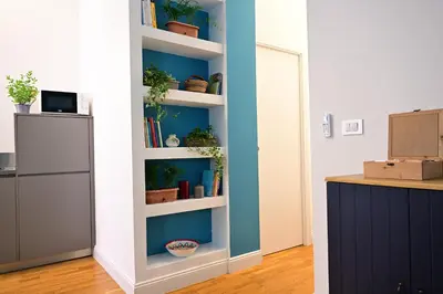 a room with a white book shelf with potted plants at At Home Montebello in Rome