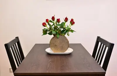 a vase with red flowers sitting on a table at At Home Montebello in Rome