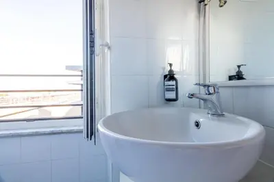 a white sink in a bathroom with a window at Joe Litty Rooms in Rome