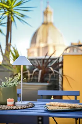 a table with a lamp and a potted plant on it at Navona design rooftop in Rome