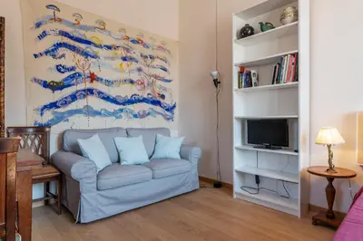 a living room with a couch and a painting at Sales - FromHometoRome in Rome