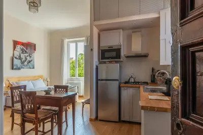 a kitchen with a stainless steel refrigerator and a table at Sales - FromHometoRome in Rome
