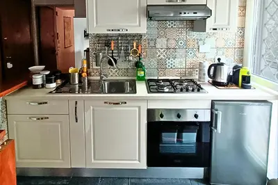 a kitchen with white cabinets and a stove top oven at Vatican Museums Balcony Apartment - Fast Wi-Fi & Metro Nearby in Rome