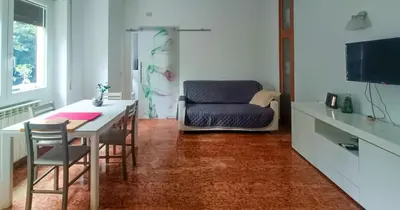 a living room with a table and a chair at Vatican Museums Balcony Apartment - Fast Wi-Fi & Metro Nearby in Rome