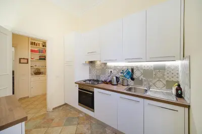 a white kitchen with a sink and a stove at La Casa del Capitano by BuddyRent in Rome