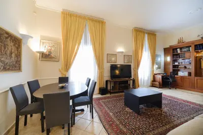 a living room with a table and chairs and a television at La Casa del Capitano by BuddyRent in Rome