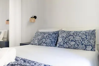 a white bed with blue and white sheets and pillows at Nextovatican Apartment in Rome