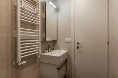 a white bathroom with a sink and a mirror at Testaccio - FromHometoRome in Rome