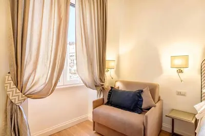 a living room with a chair and a window at Riboty 10 Suites in Rome