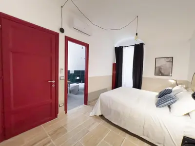 a bedroom with a bed and a red door at Tasso Designer Suite - Colosseum Esquilino in Rome