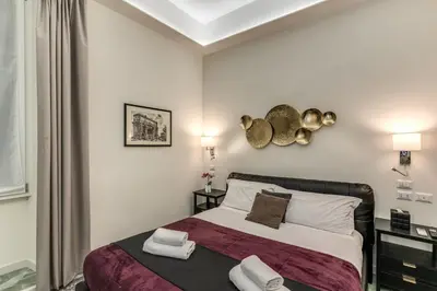 a bedroom with a bed with two towels on it at Adriana 5 Luxury rooms in Rome
