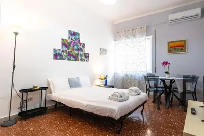 a bedroom with a bed and a table with chairs at Magiù Apartment in Rome