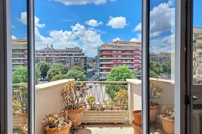 a balcony with potted plants and a view of a city at Comfy home for family next to Metro in Rome