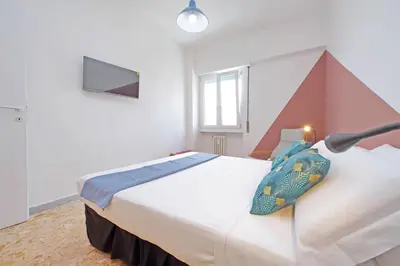 a bedroom with two beds and a tv on the wall at Comfy home for family next to Metro in Rome
