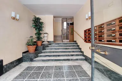 a hallway with stairs with potted plants and a door at Comfy home for family next to Metro in Rome