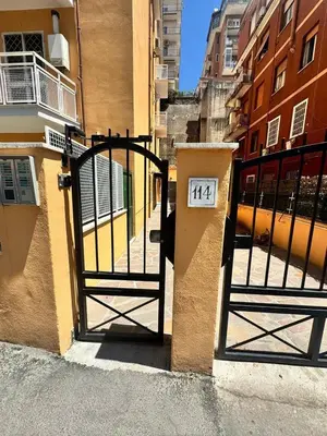 a gate with a sign on it next to a building at Little Apartment in Rome