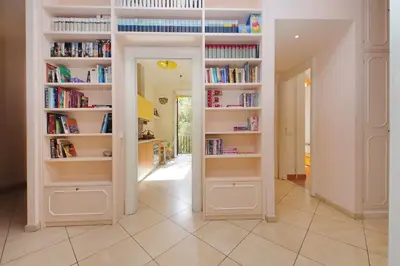 a hallway with white book shelves with books at At the Vatican Ottaviano 2 bedrooms 2 baths in Rome