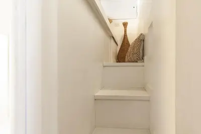 a stairway with white walls and white stairs with vases at Piazza Navona Elite Flat in Rome