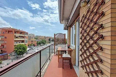 a balcony with a table and a view of a street at Aria di Roma Appartamento in Rome