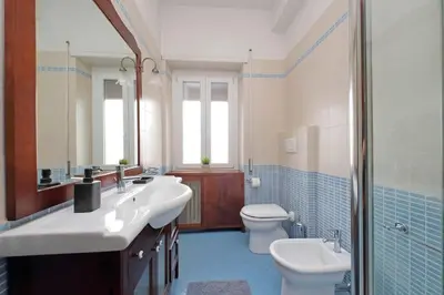 a bathroom with two sinks and a toilet at Aria di Roma Appartamento in Rome