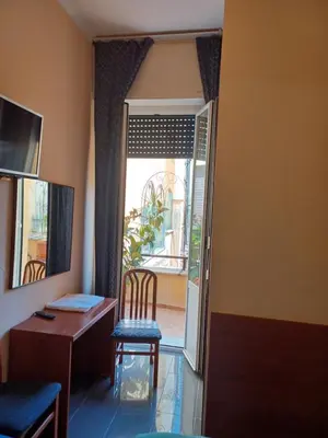 a room with a desk and a chair next to a door at PITAGORA Rooms in Rome