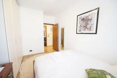 a bedroom with a white bed with a picture on the wall at Luminous 2BR Family Apartment in Residential Area in Rome