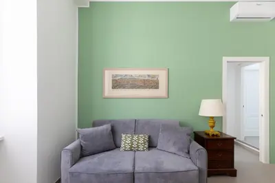 a living room with a gray couch and a lamp at iFlat Soft & Relaxing apt in Trastevere in Rome