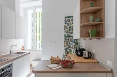 a kitchen with white cabinets and a wooden counter top at iFlat Soft & Relaxing apt in Trastevere in Rome