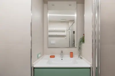 a white bathroom with a sink and a mirror at iFlat Soft & Relaxing apt in Trastevere in Rome