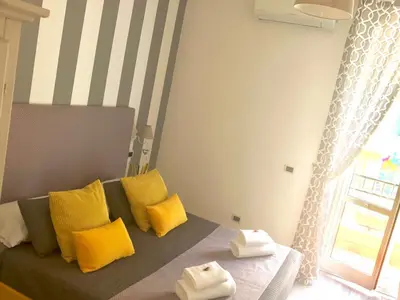 a room with a couch with yellow pillows and a window at B&B Exa Rooms - Just Rome in Rome