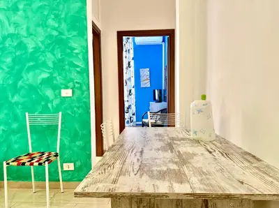 a table and chairs in a room with a green wall at Casa Flavia in Rome
