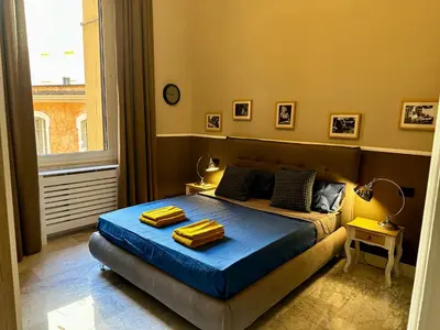 a bedroom with a bed with blue sheets and a window at The Great Maison in Rome