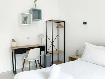 a bedroom with a bed and a desk and a chair at Casa Vittoria in Rome