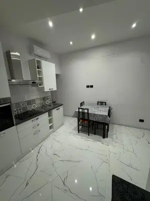 a kitchen with a table and a kitchen with marble floors at Heaven of Maya in Rome