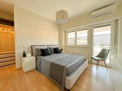 a bedroom with a large bed and a chair at Lumen House - Attico con Suite in Rome